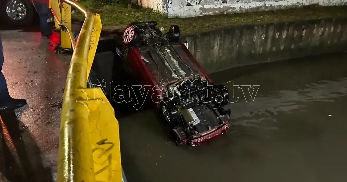 Corriente arrastra vehículo por canal Sabino y lo deja volcado frente a bomberos en Tepic (1 de 3)