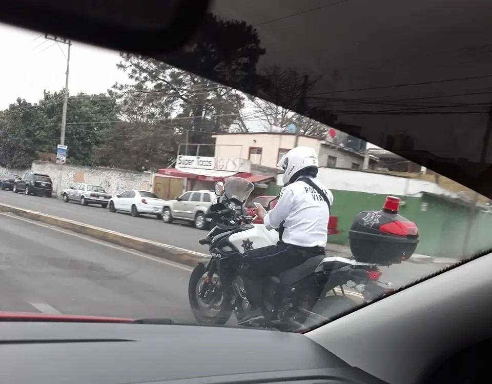 Captan a policía vial usando el celular mientras manejaba moto sin placas